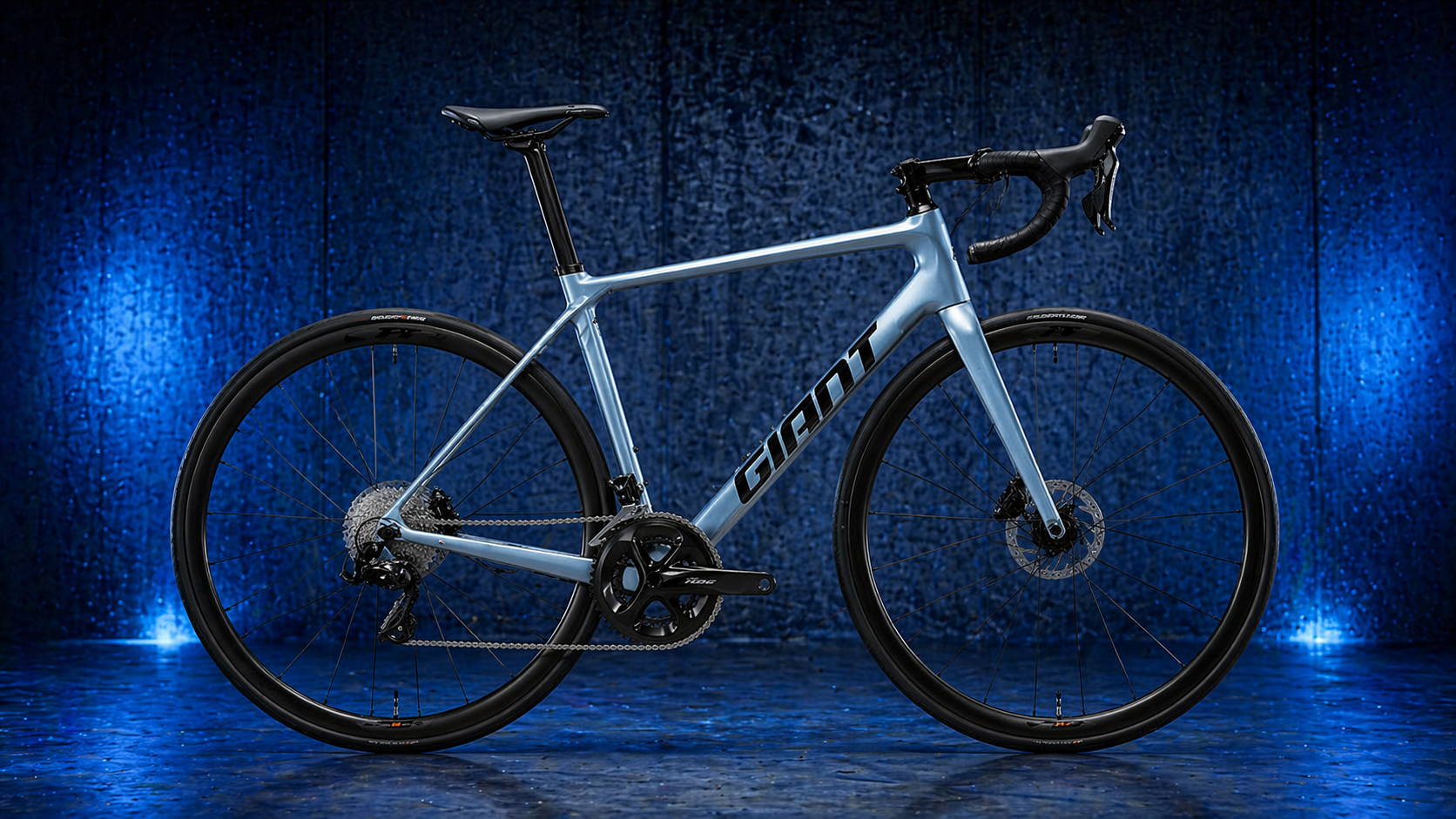 Giant TCR Advanced racefiets in strak zijaanzicht tegen blauwe industriële achtergrond, snelle carbon klimfiets voor artikel over de beste tweedehands racefietsen.