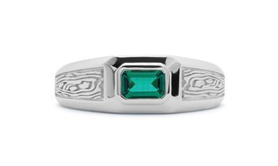 White gold signet ring with emerald, emerald cut, on white background.