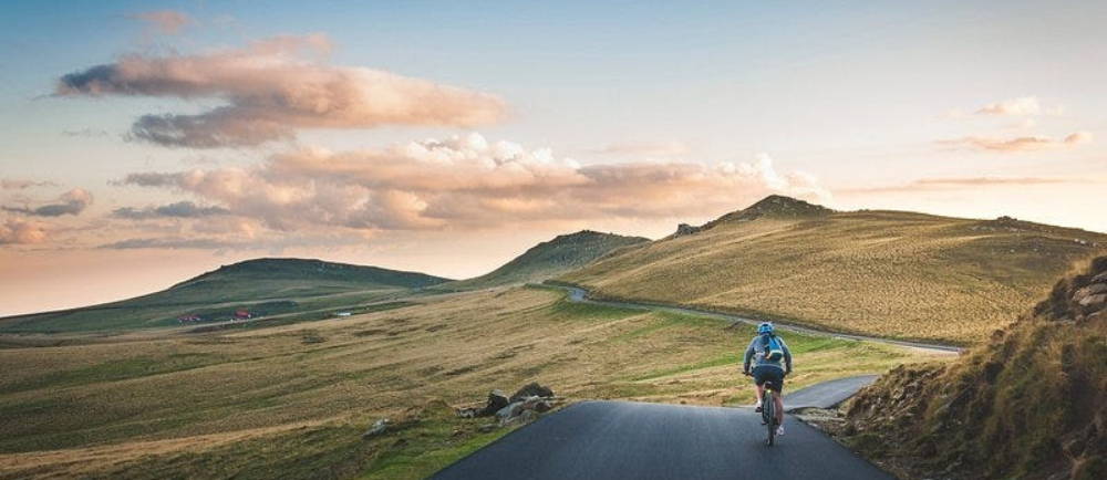 Cyclist on road in rolling mountains