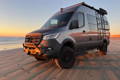 Camper Vans gathered at a campfire at sunset