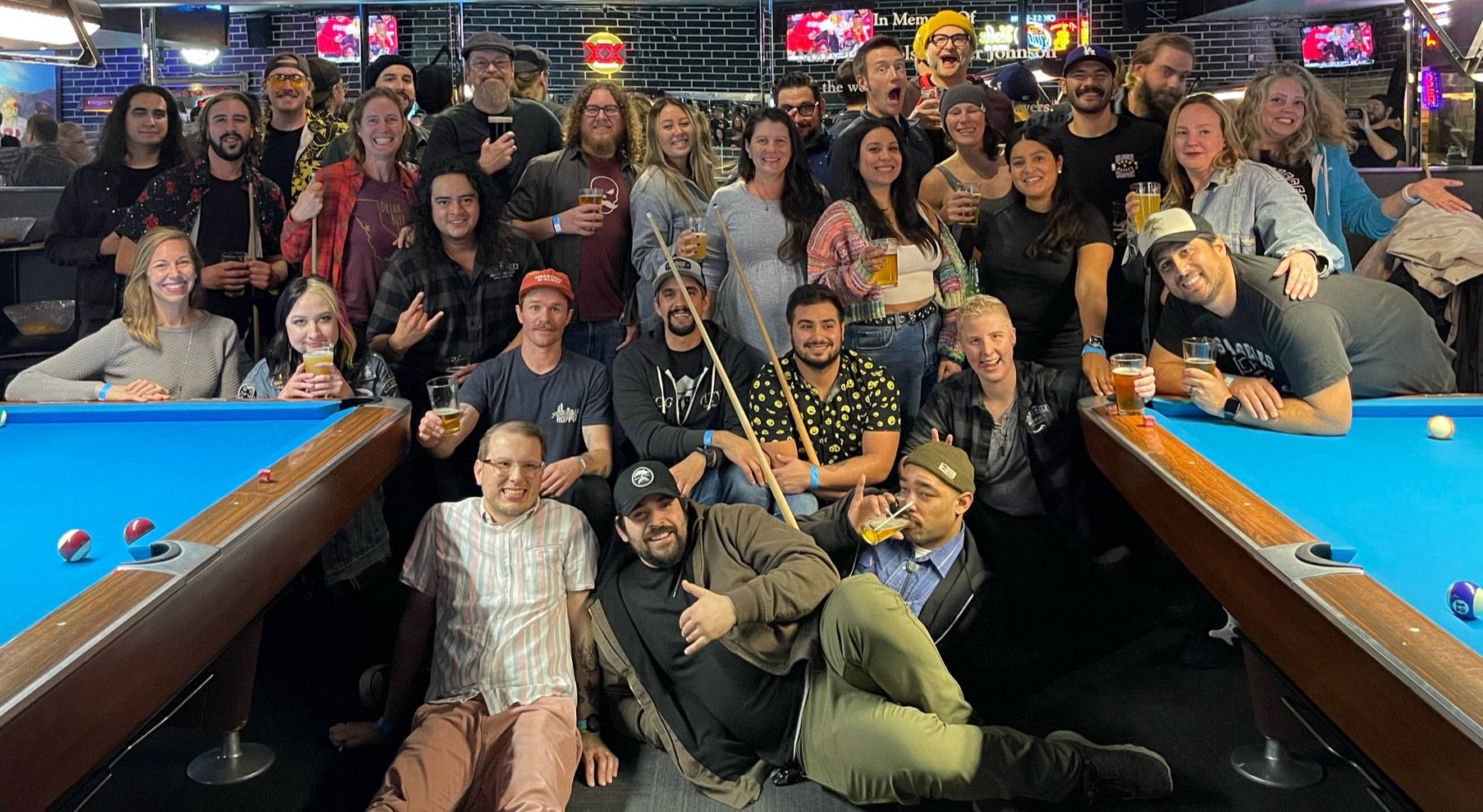 Smog City Brewing team photo gathered together in a pool hall