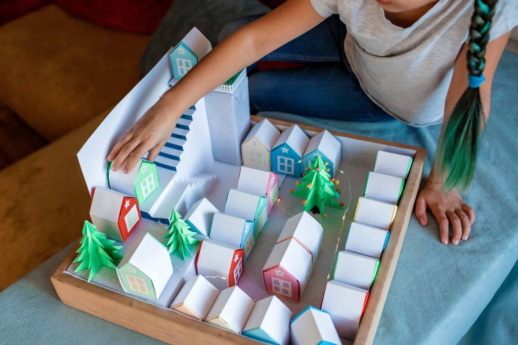 Girl playing with cartoon-made neighborhood houses.