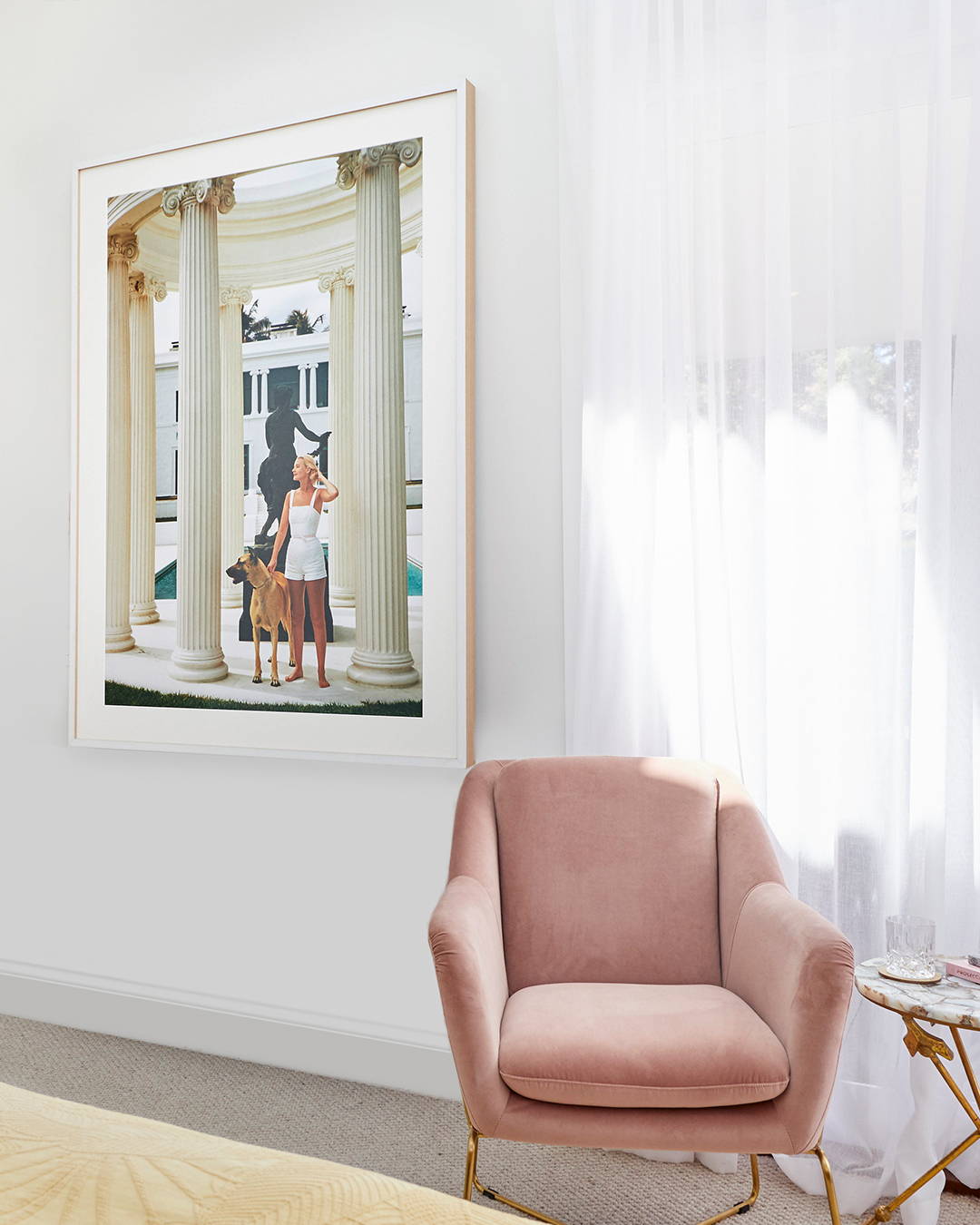 A TV-Mirror in a black and gold frame in a light-filled bedroom setting.