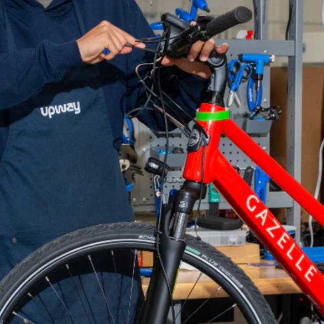 an Upway mechanic working on a gazelle electric city bike