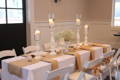 white rectangular tablecloth on a table with burlap table runners and candles