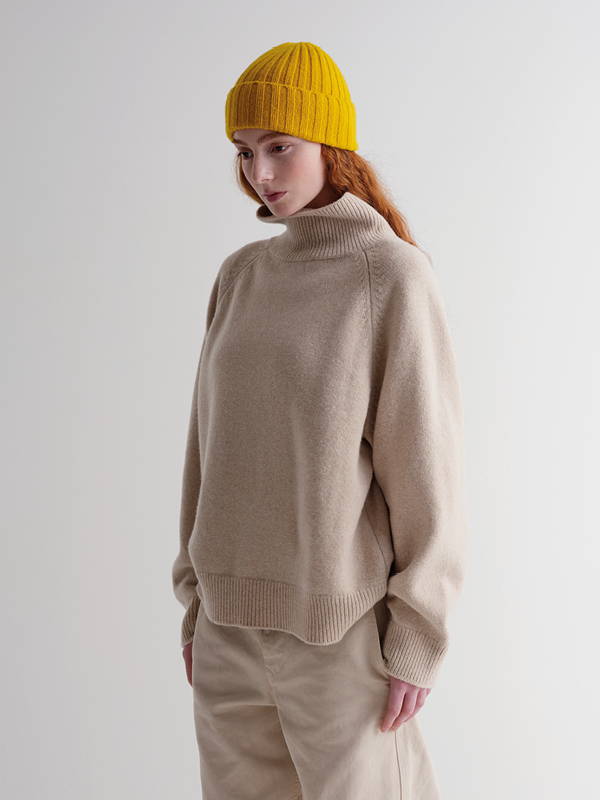 Model wears plain ribbed hat golden eye