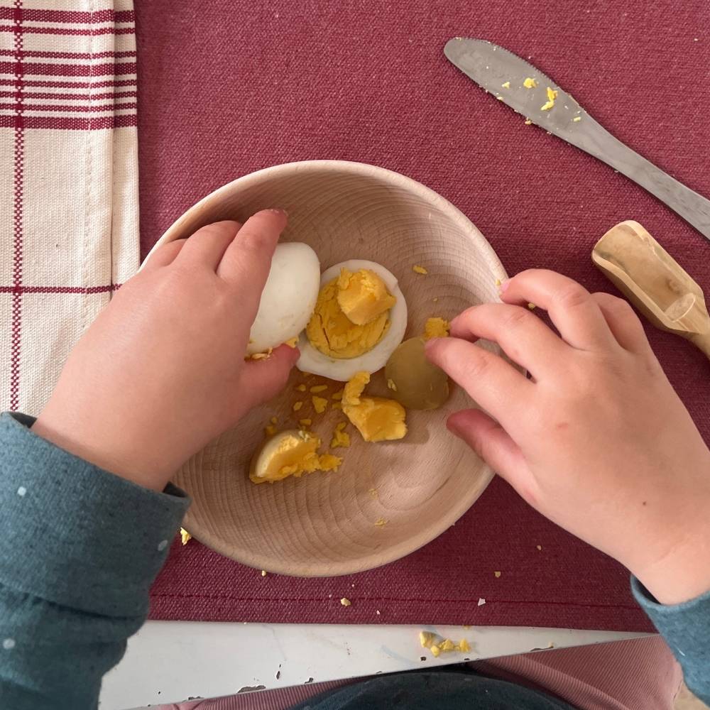 Un petit garçon utilise des couverts enfant pour dresser le couvert