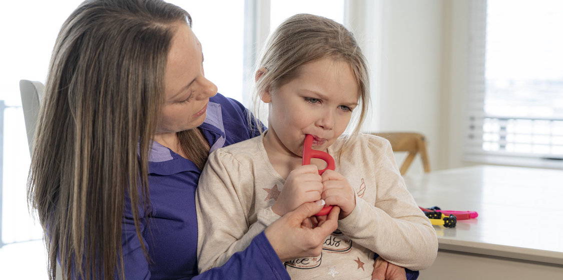 B-buddy hand-held chew oral tool being used with child and therapist