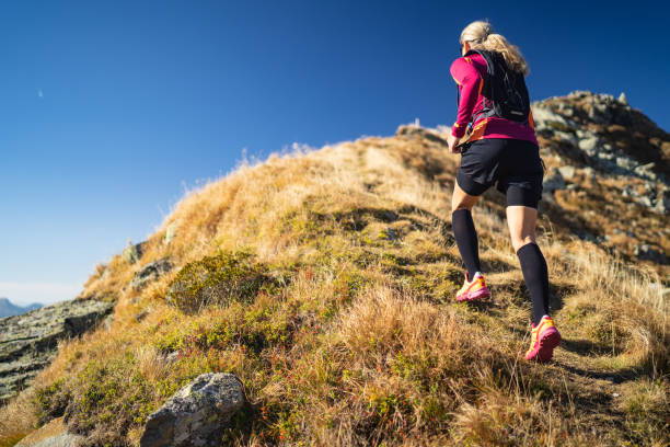 A woman running in the field while wearing black color color compression socks.