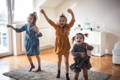 Three girls dancing in their playroom.