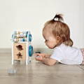 Little girl playing with the Montessori Learning Rocket toy.