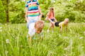 Children playing wheelbarrow walk in the park.