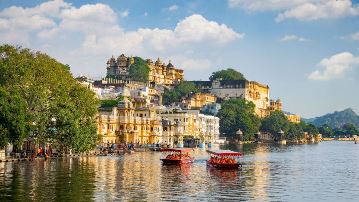ICity Palace and tourist boat on lake Pichola in Rajasthan, India
