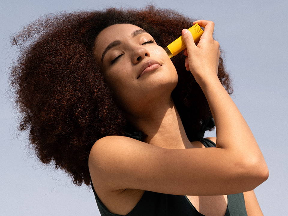 Woman applying a stick on her face