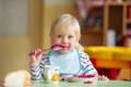 Toddler girl holding a spoon. 