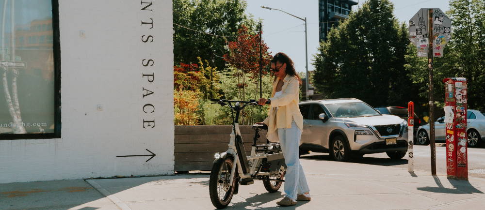 Woman with Specialized electric cargo bike on sidewalk