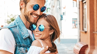 Belle fille souriante et son beau petit ami portant des lunettes de soleil.