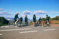Un home, une femme, et plusieurs enfants d'ages differents a velo sur une route