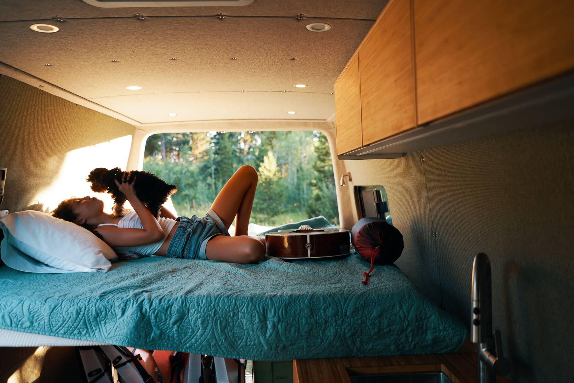 Interior view of The Bivy ProMaster 136 conversion showing built-in galley and under-bed storage