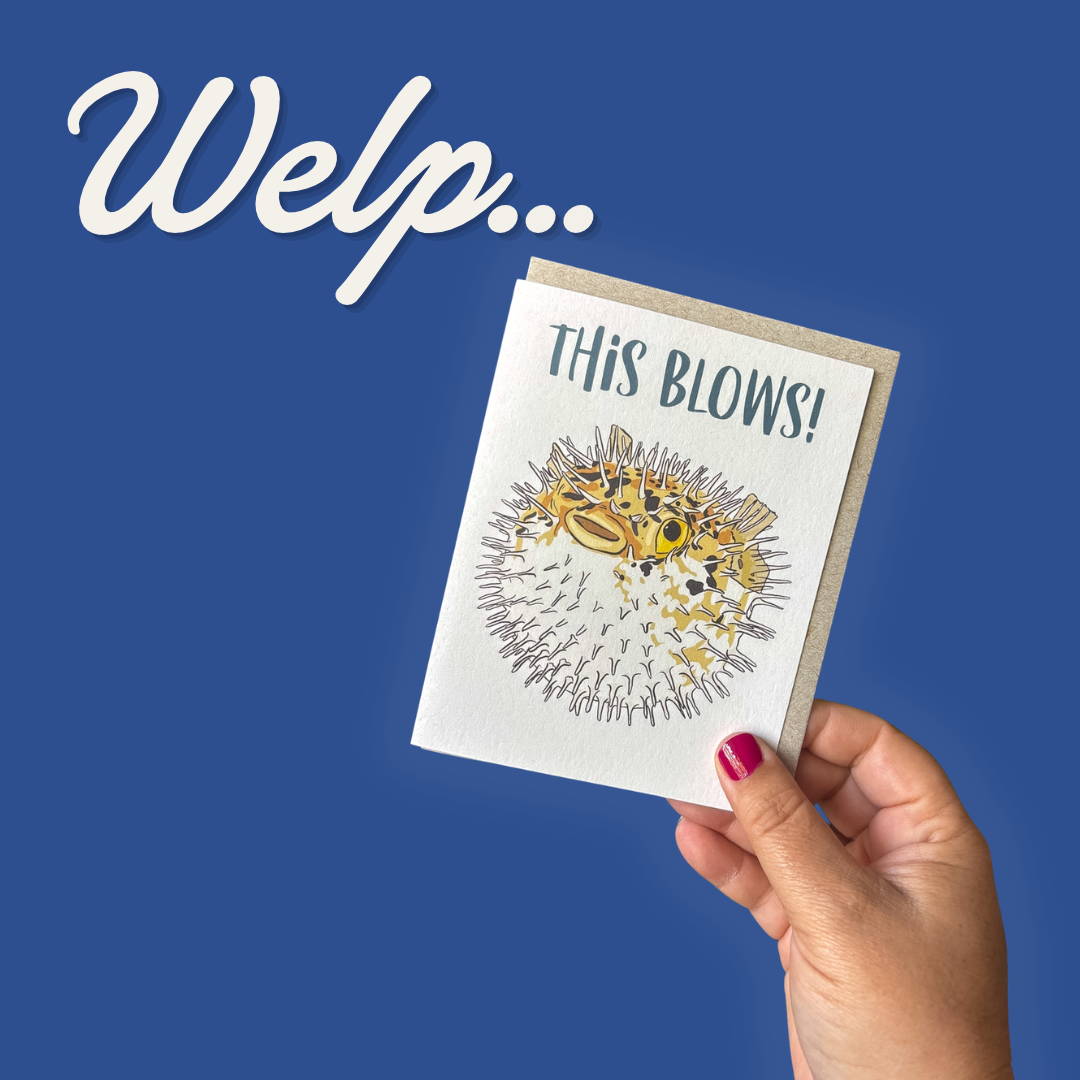 Blue square with hand holding "This Blows" card featuring an illustrated blowfish with "Welp.." written above it