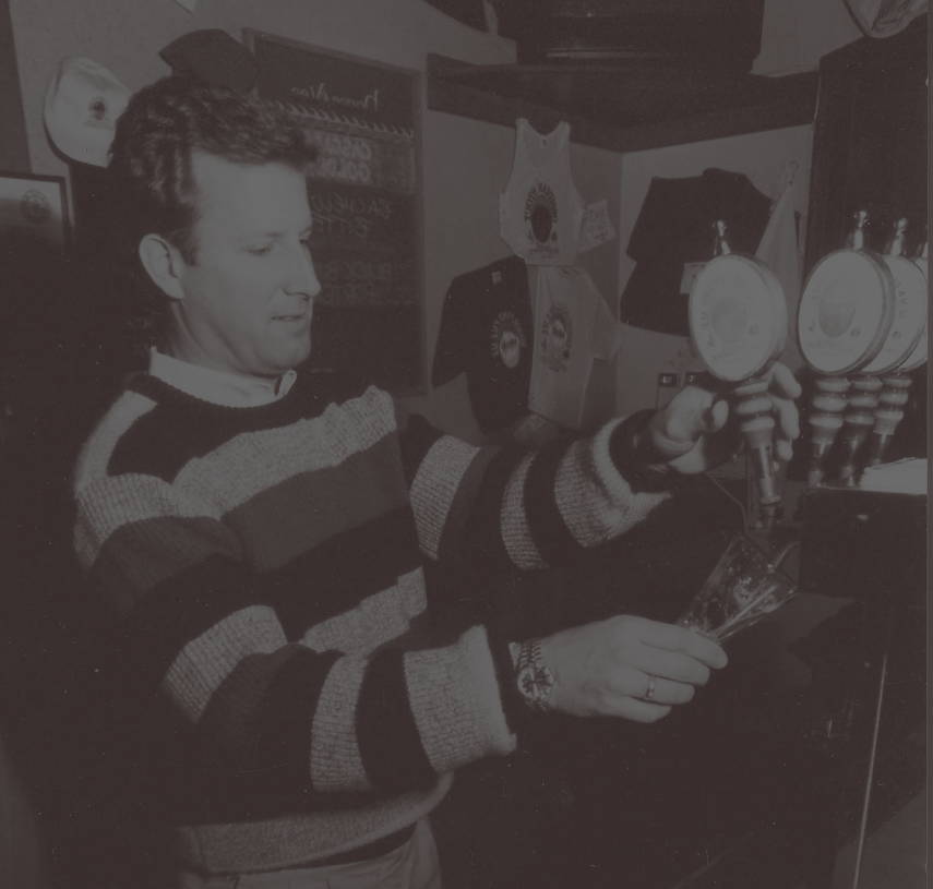 decorative image, black and white photo of a person pulling a pint
