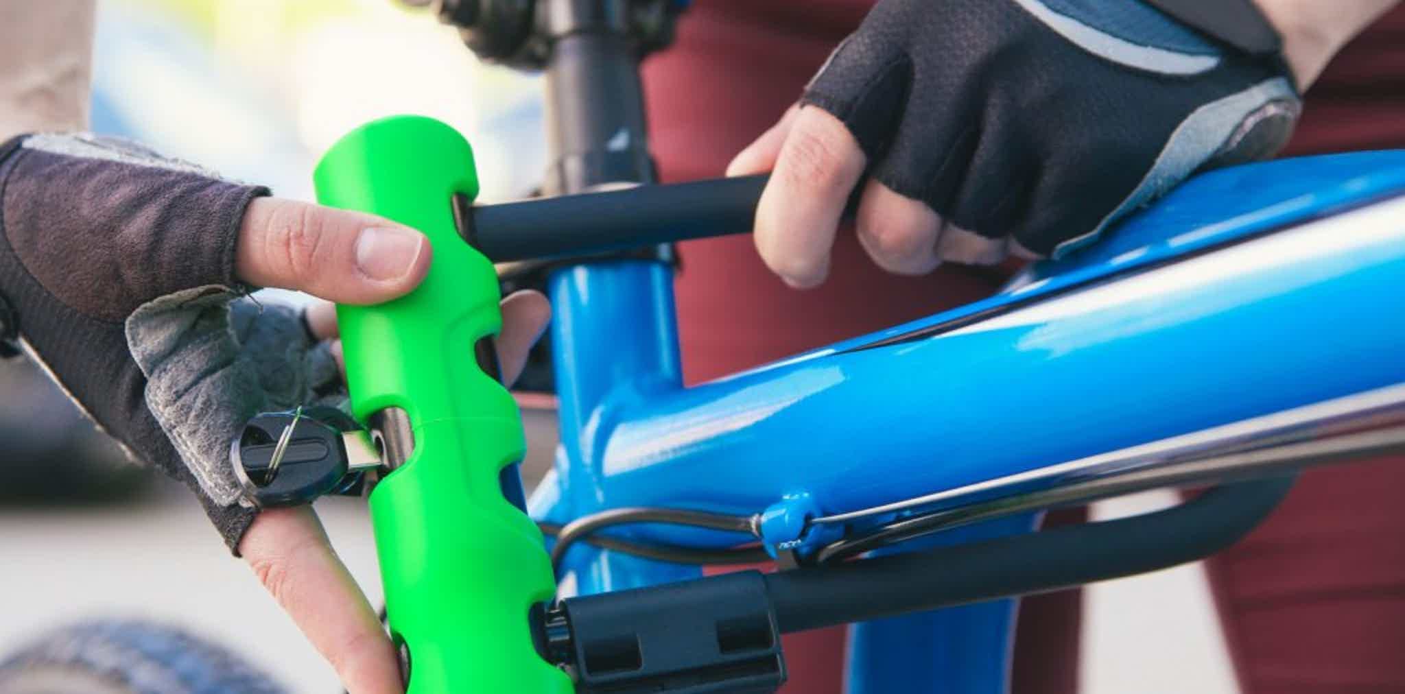 Imagen de recurso de una persona colocando un candado en forma de U a una e-bike.