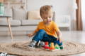 Little boy playing with colorful Montessori wooden blocks.