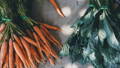 A bunche of carrots and kale on a burlap sack