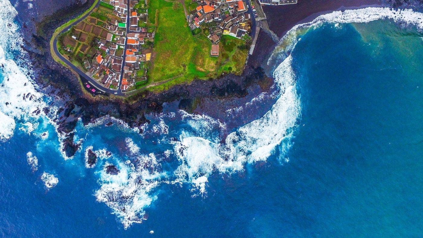 Azores Portugal Travel Guide Rocky Shoreline and Green Landscape Waves Crashing Against Shore