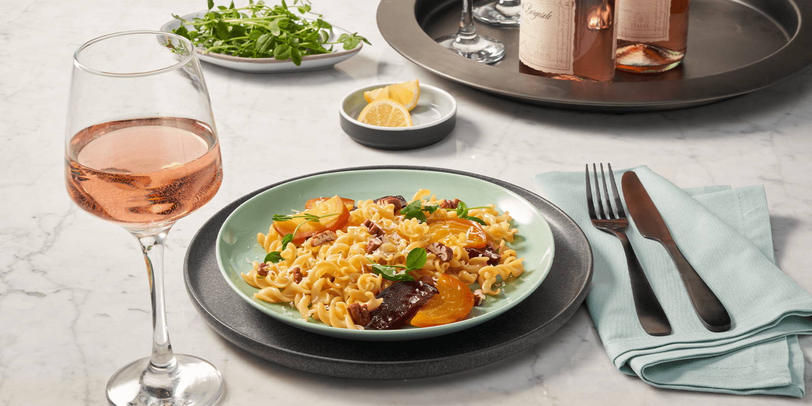 Place setting with pasta and wine.