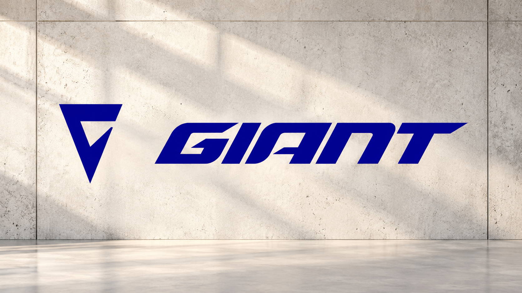 Logo Giant bleu sur un mur en béton clair, illustration des problèmes de vélo électrique Giant