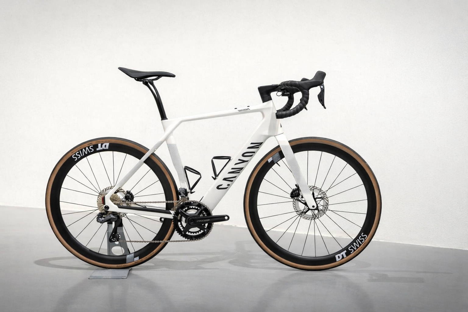Canyon Endurace carbon racefiets met DT Swiss wielen en schijfremmen, witte endurance racefiets gefotografeerd in zijaanzicht op neutrale achtergrond.