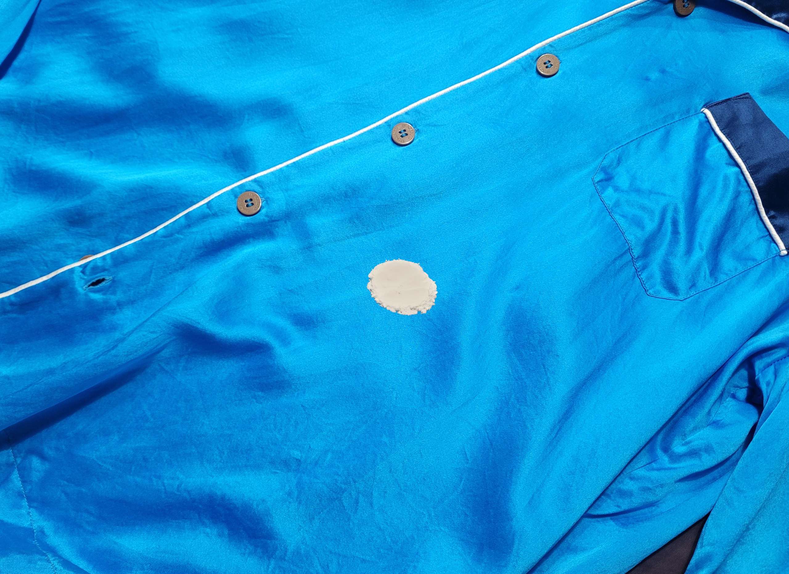 photo of baking soda covering a stain on a satin shirt