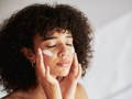 Woman applying cream on her face