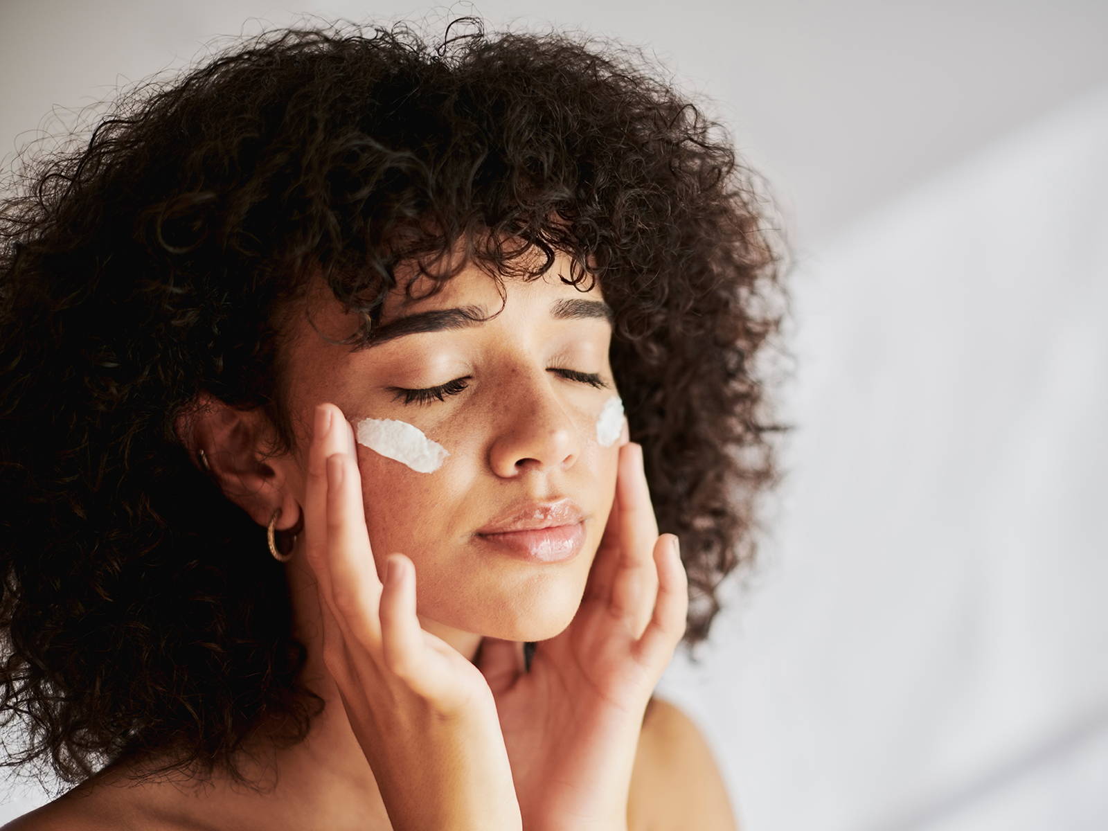 Woman applying cream on her face