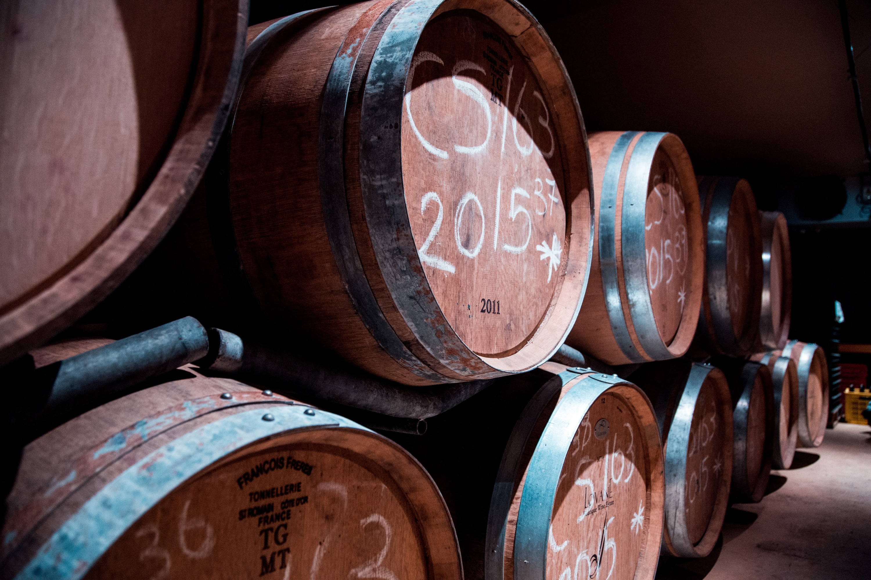 Wine barrels in storage displaying dated wine to compare old world vs new world wine making techniques.  