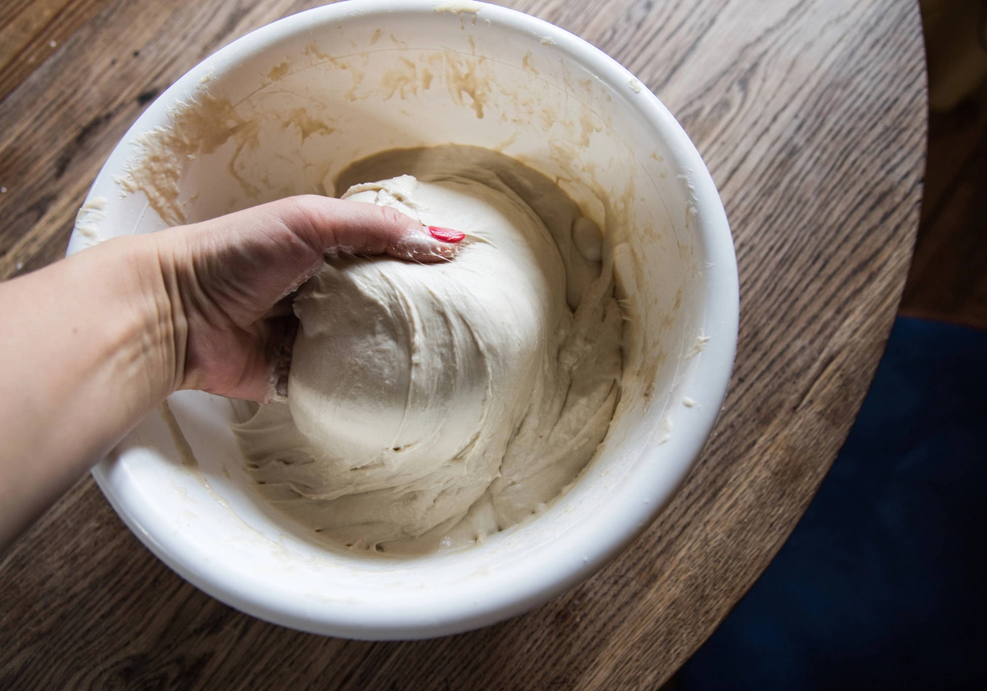 Hands kneading wild-fermented sourdough dough during the bread-making process.