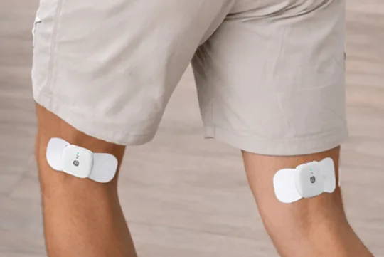 ワイヤレスTENSポッドを両足に装着し、自由に動きながら痛みを和らげます。