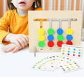 A little girl in an orange shirt posing behind the Montessori Double-Sided Matching Game. 