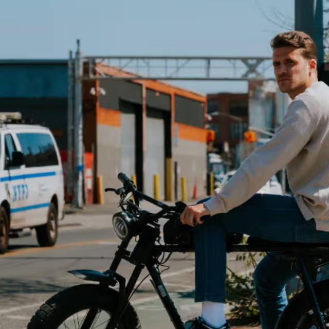 a man sitting on an electric mini moto in a city
