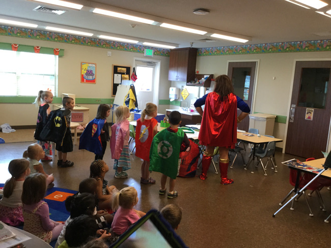 Costume Kim, dressed as wonder woman with a group of young Primrose students dressed as different superheroes visit a class