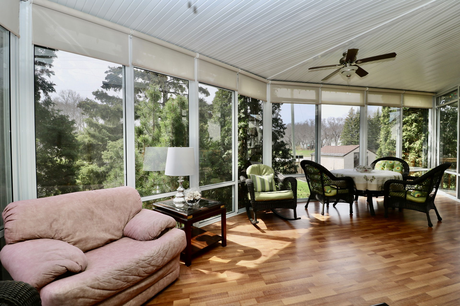 sunroom / solarium with wood-type flooring and a ceiling fan