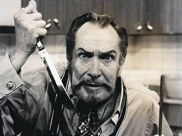 A classic photo of Vincent with a menacing look holding a knife close to him on his kitchen counter.