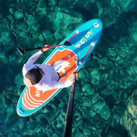 Customer with her dog seating in TIKI best inflatable paddle board for dogs and smile