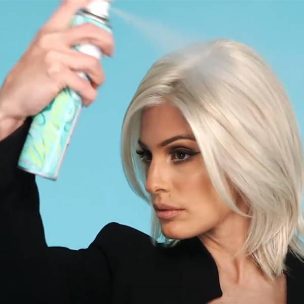 Model spraying her hair piece with dry shampoo