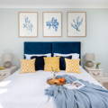 Set of three seaweed art prints above a bed
