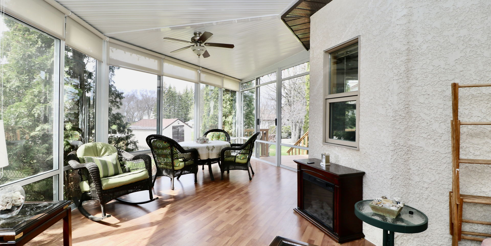 sunroom / solarium with wood-type flooring and a ceiling fan