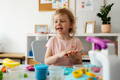 Little girl playing with clay in her Montessori playroom. 