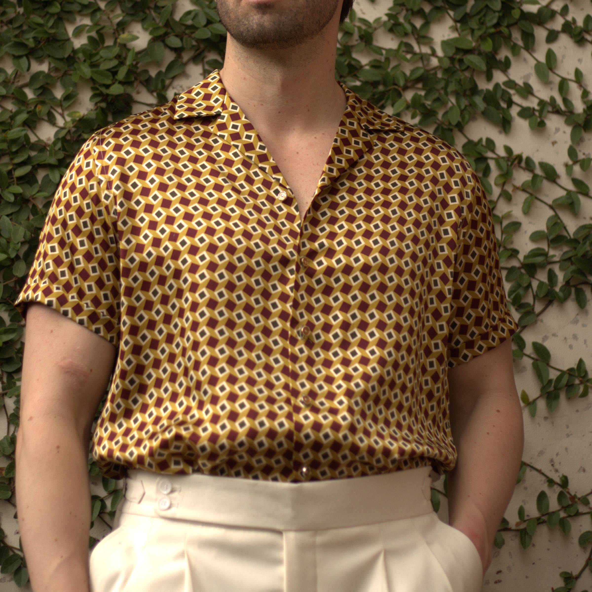 close up image of a male model wearing a gold bowling silk shirt