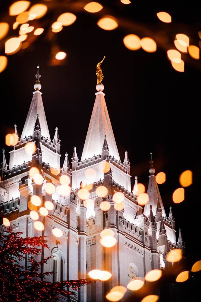 Salt Lake Temple spires framed by Christmas lights. 